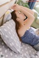 A woman laying on a bed with her head on a pillow.