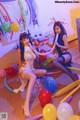 A couple of women sitting next to each other in front of balloons.