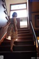 A woman is standing on the stairs of a house.