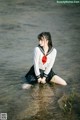 A woman in a sailor outfit sitting in the water.