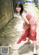 A woman in a red dress is posing for a picture.