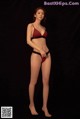 A woman in a red and black bikini posing for a picture.