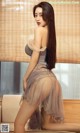 A woman in a gray dress sitting on a couch.