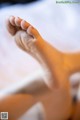 A close up of a woman's bare feet on a bed.