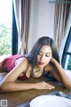 A woman in a red dress laying on a table.