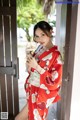 A woman in a red kimono is posing for the camera.